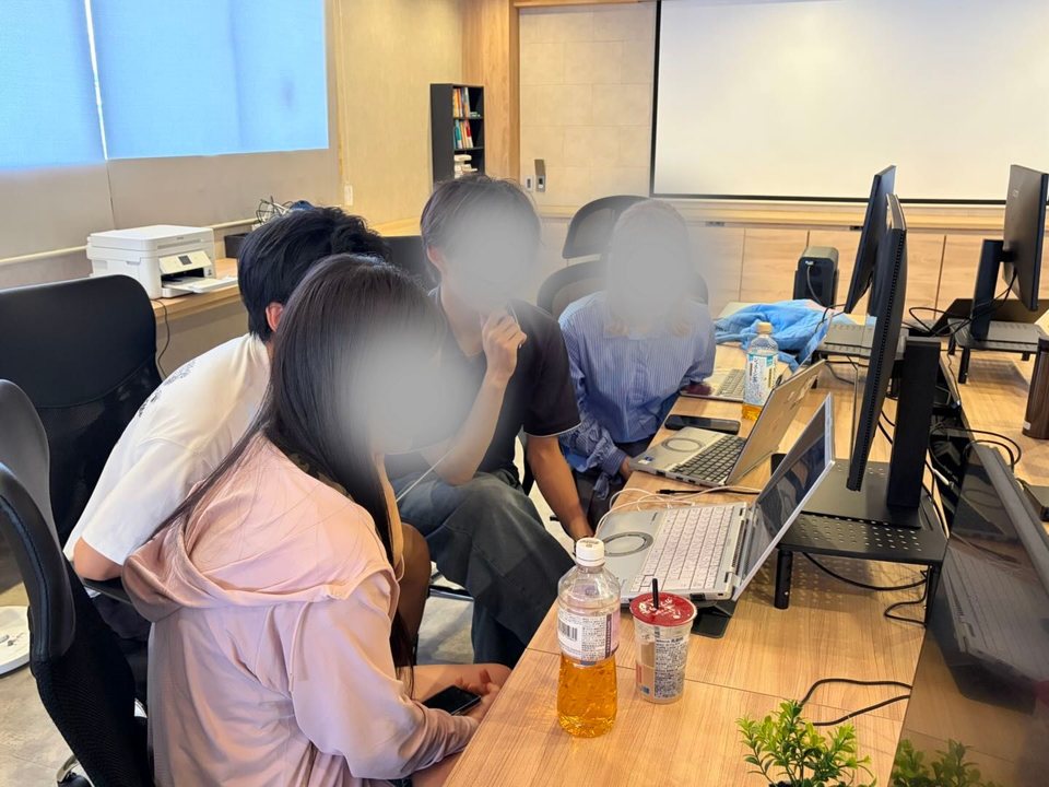 GUILDの参加者が一台のノートPCを囲んで話し合う様子